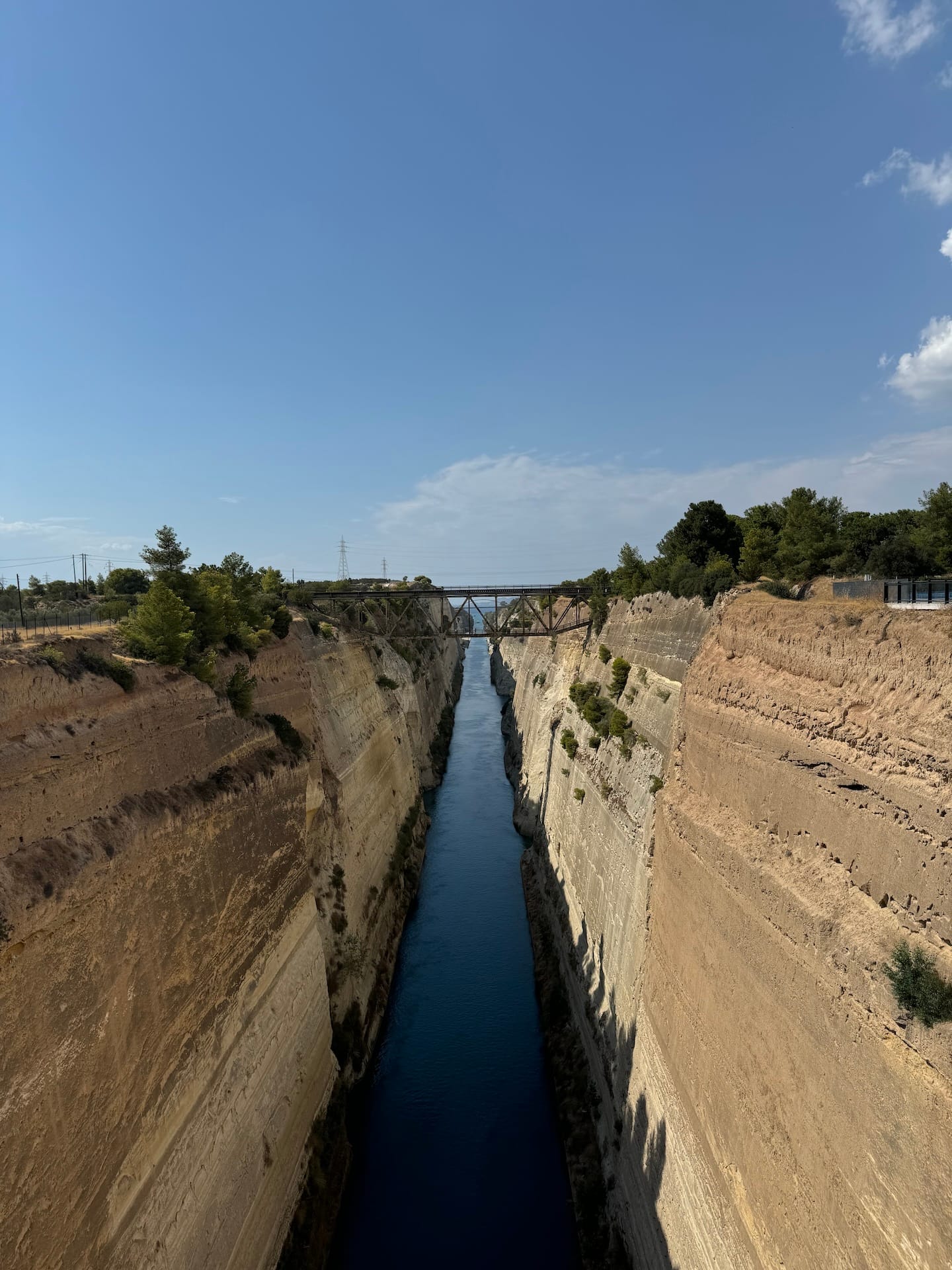 Blick von einer Brücke in den Kanal von Korinth. Unten Wasser, links und rechts die senkrechten Felsen.