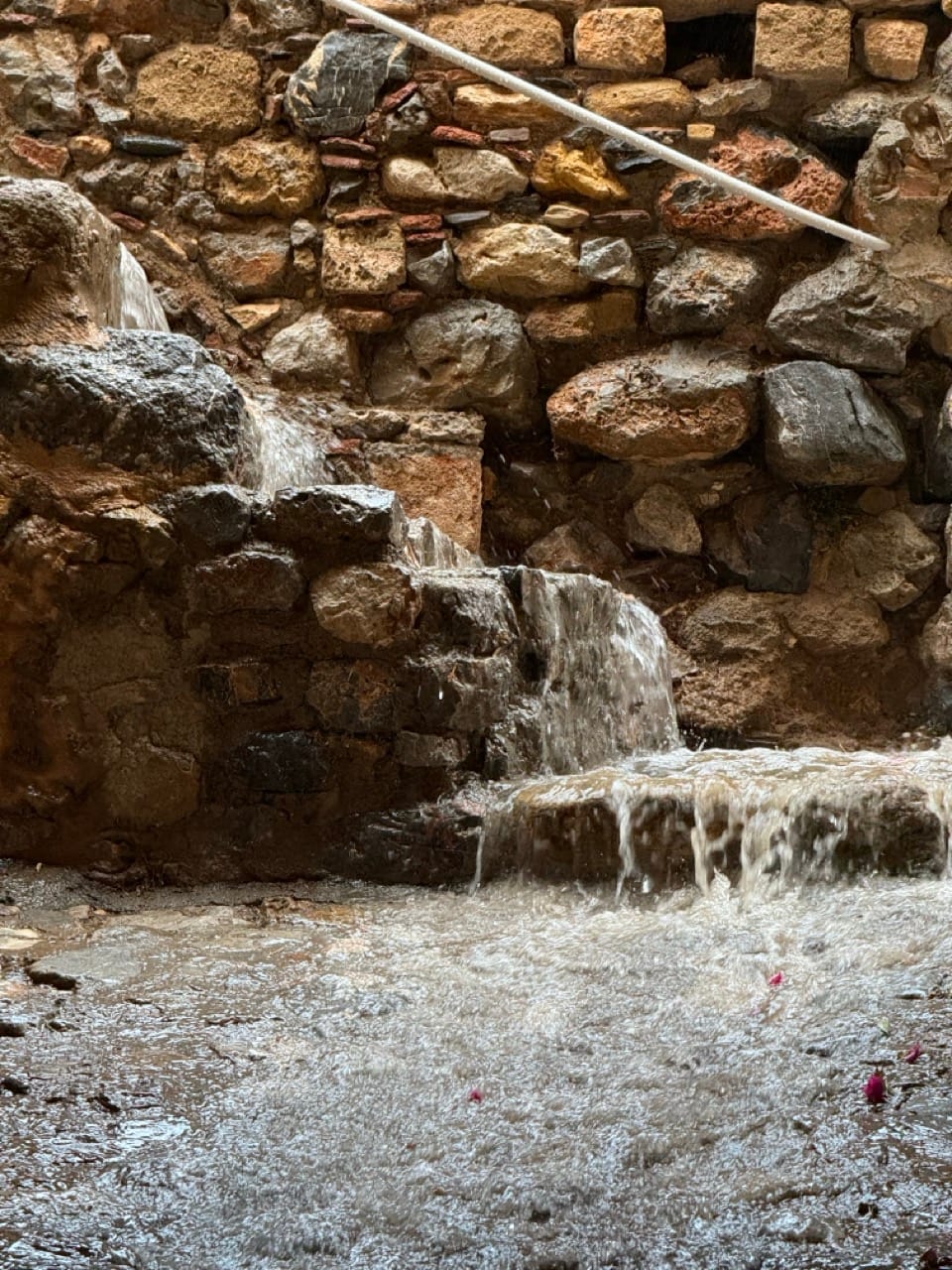 Ein Regenwasserbach fließt alte Treppen runter.