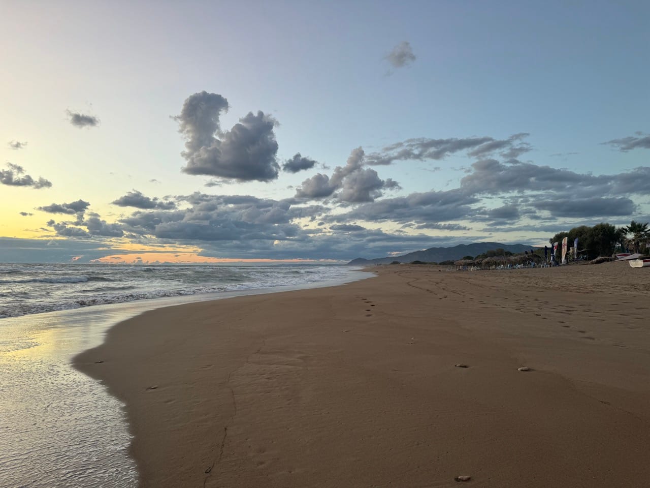 Links das Meer, rechts der Strand mit einer Strandbar.