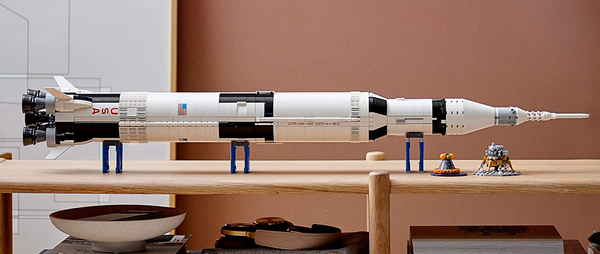 Die LEGO Saturn V auf einem Holzregal liegend.