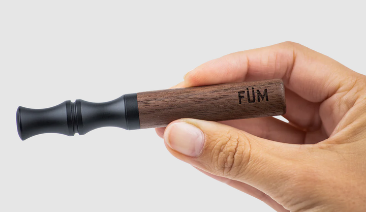 Füm mit schwarzem Mundstück und Walnusholz-Körper, gehalten in einer Hand.